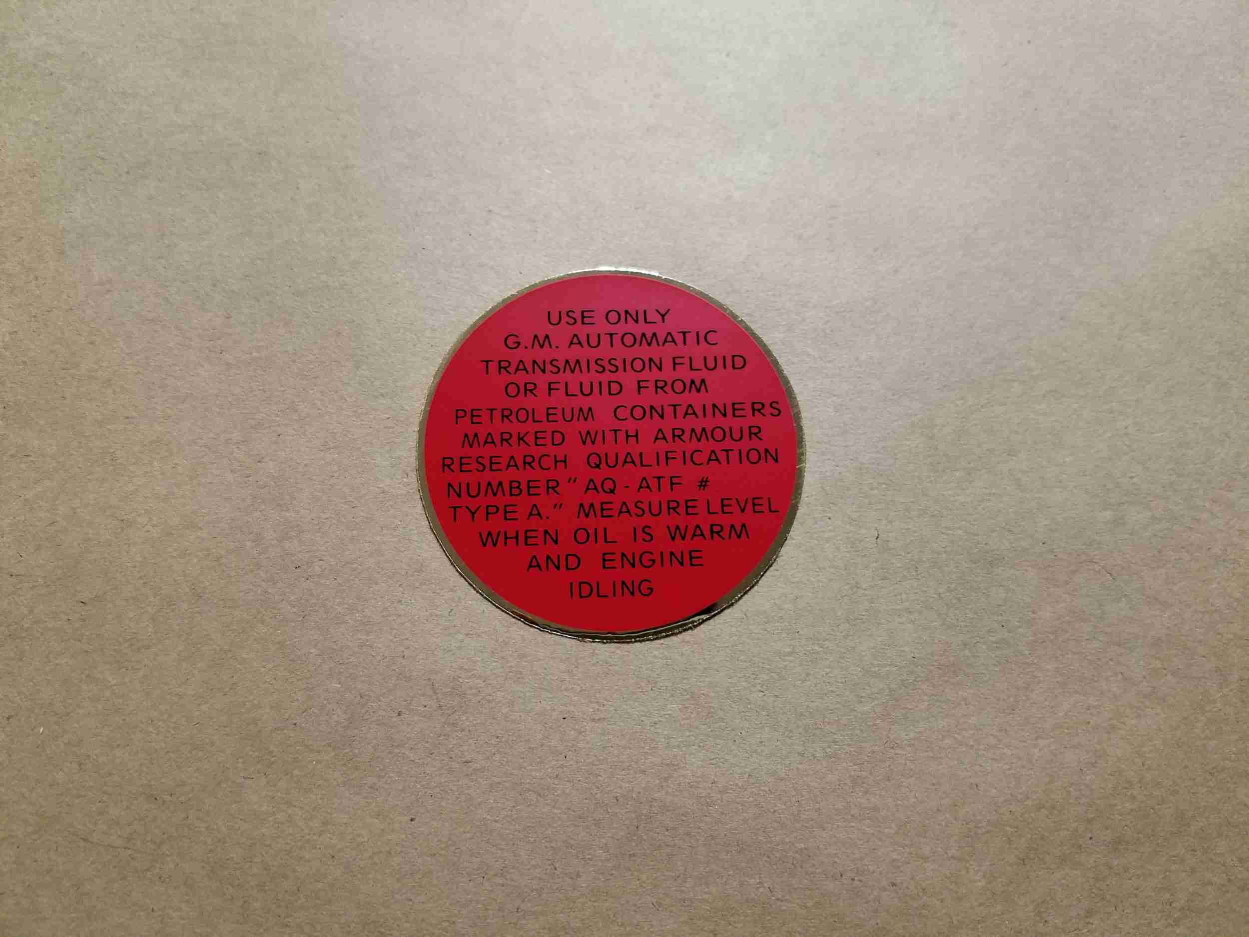 1948-54 Hydramatic Transmission Filler Cover Decal, on plug underneath carpet in passenger compartment