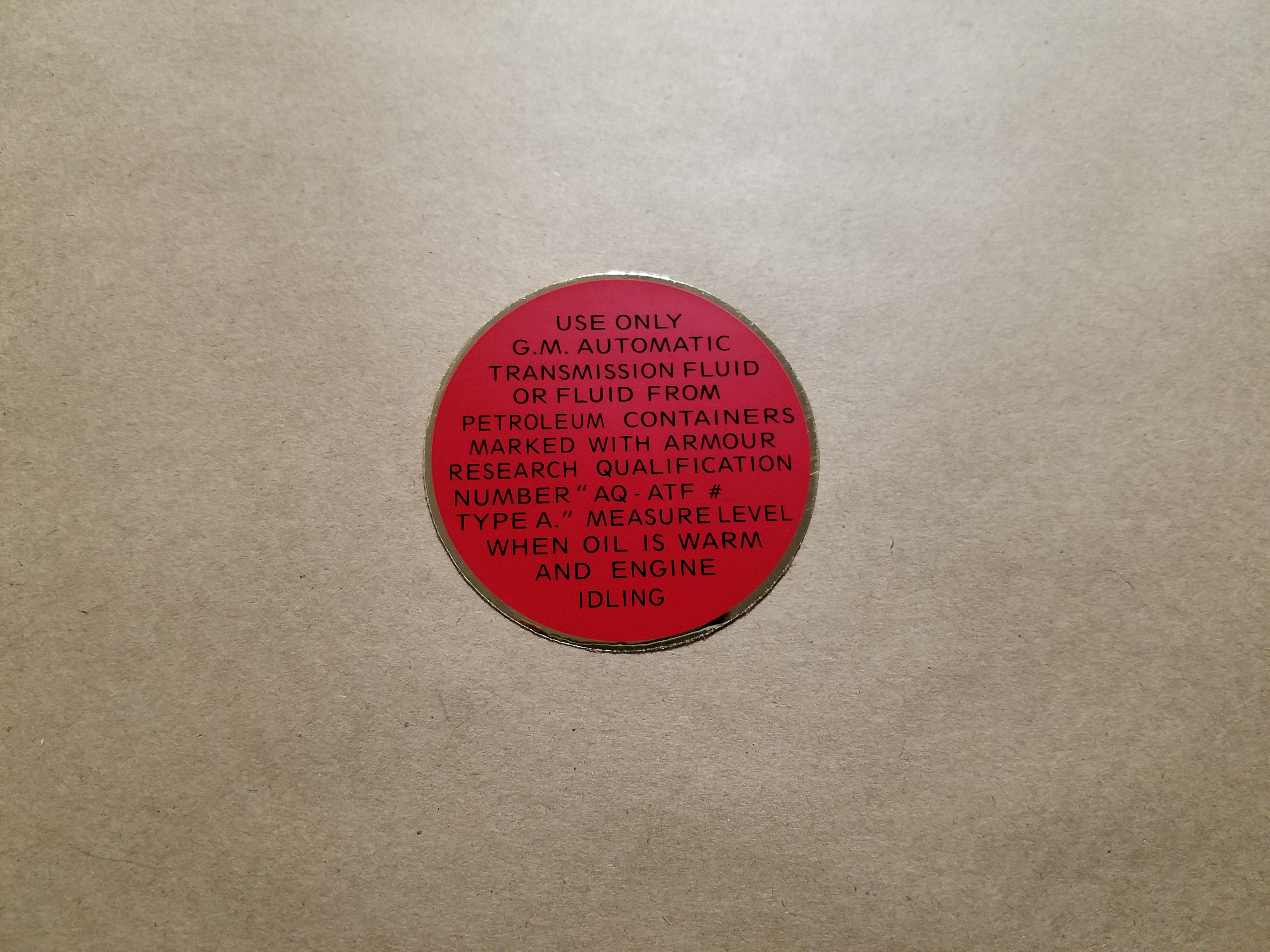 1948-54 Hydramatic Transmission Filler Cover Decal, on plug underneath carpet in passenger compartment